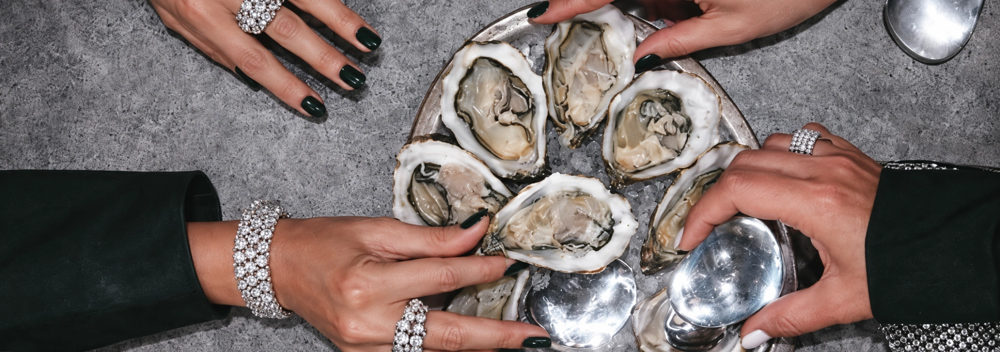 Jewellery editorial with oysters, silverware and emerald green styling